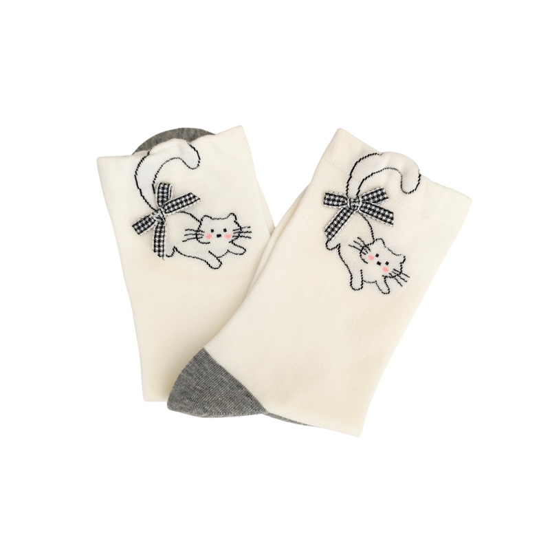 White crew socks with grey toes and an embroidered cat wearing a checkered bow near the cuff.