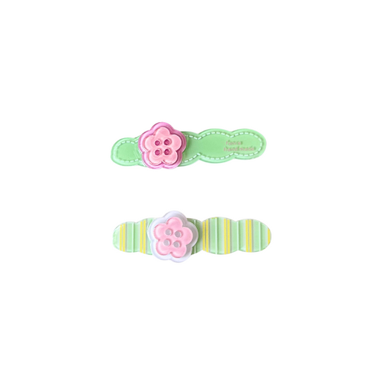 A playful 2‑piece flower‑button hair clip set featuring pastel bases and pink flower buttons — perfect for soft‑girl, kawaii, and everyday cute hairstyles.