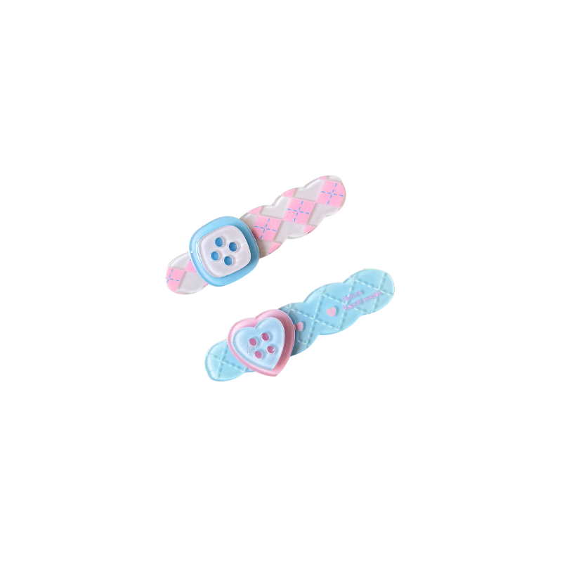 A sweet pastel hair clip duo featuring a pink criss‑cross clip with a button detail and a blue quilted clip with a heart button — perfect for soft‑girl, kawaii, and everyday cute hairstyles.