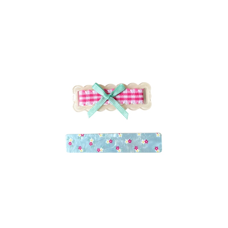 A sweet 2‑piece pastel hair clip set featuring a scalloped gingham bow clip and a floral blue clip — perfect for soft‑girl, kawaii, and everyday cute hairstyles.