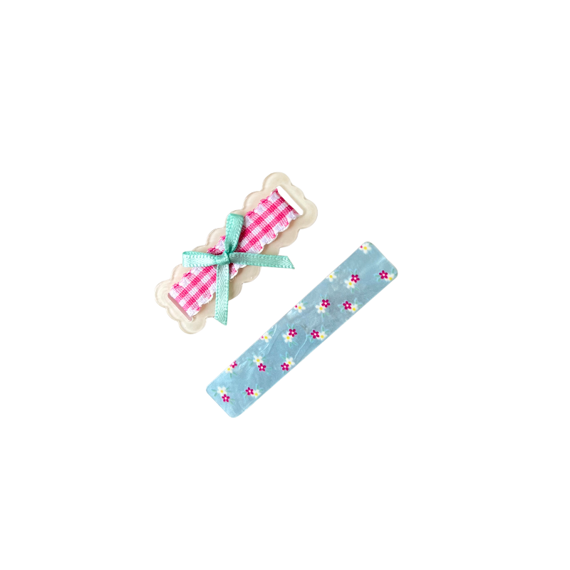 A sweet 2‑piece pastel hair clip set featuring a scalloped gingham bow clip and a floral blue clip — perfect for soft‑girl, kawaii, and everyday cute hairstyles.