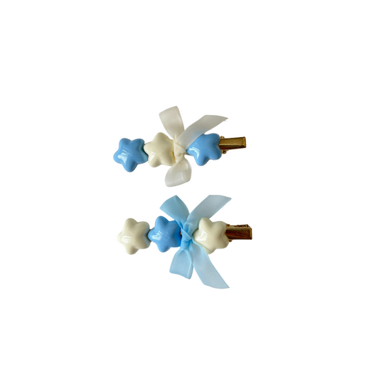 A dreamy pastel hair clip duo featuring blue and white star accents with matching ribbon bows — perfect for soft‑girl, kawaii, and everyday cute hairstyles.