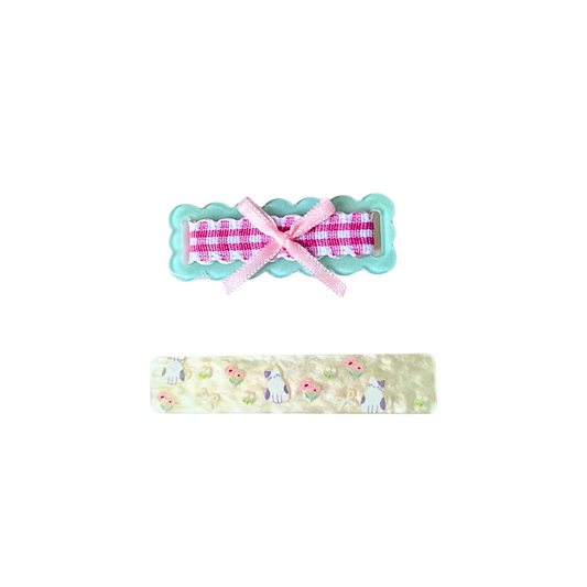 A charming 2‑piece pastel hair clip set featuring a scalloped gingham bow clip and a kitty‑floral barrette — perfect for soft‑girl, kawaii, and everyday cute hairstyles.