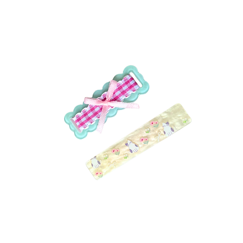 A charming 2‑piece pastel hair clip set featuring a scalloped gingham bow clip and a kitty‑floral barrette — perfect for soft‑girl, kawaii, and everyday cute hairstyles.