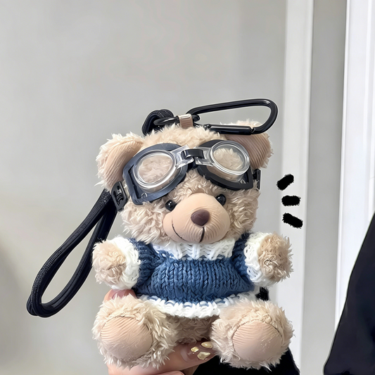 Two plush teddy bear bag charms wearing striped sweaters and goggles, each attached to a clip for bags or keys
