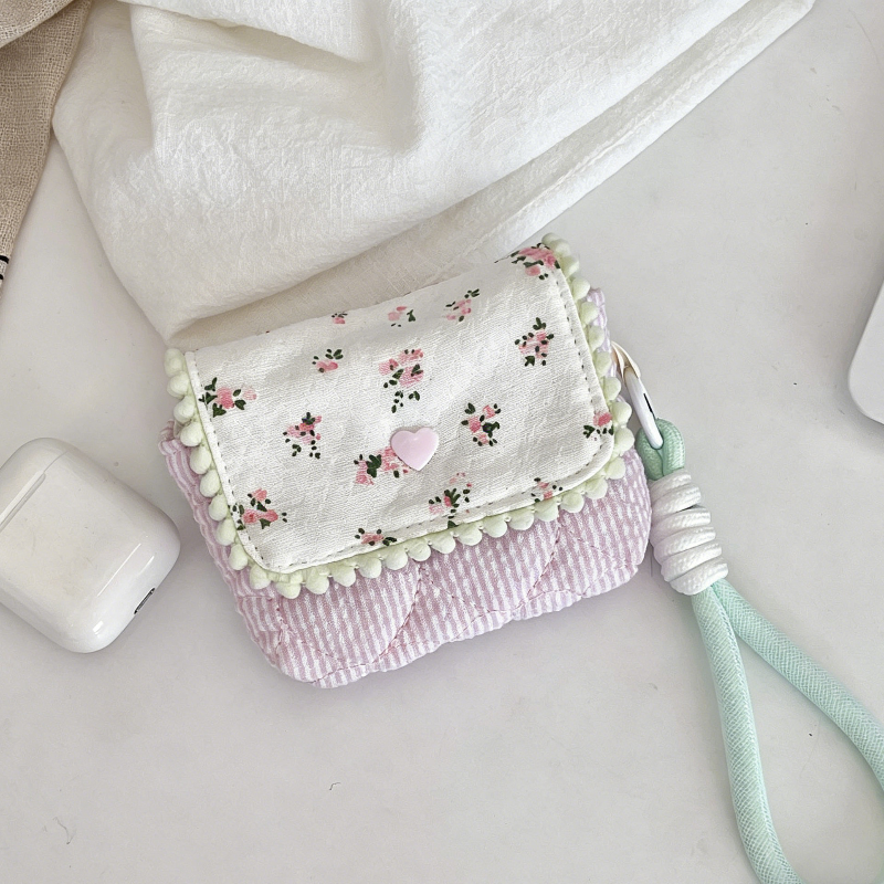 Four small quilted pouches in pastel colours, each with a patterned flap, pom‑pom trim, heart button, and matching wrist strap