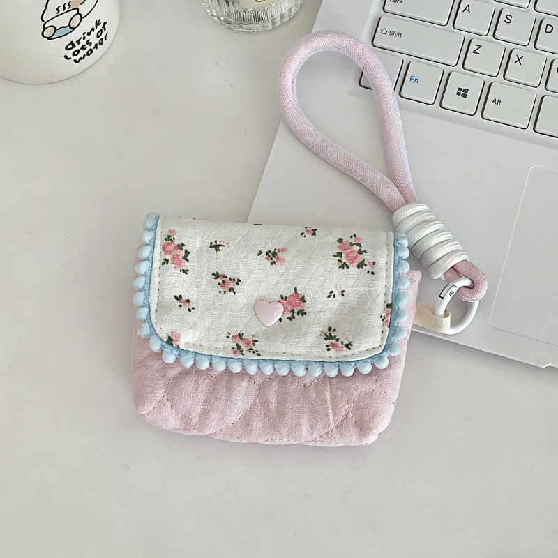 Small floral pouch with a pink strap on a light surface