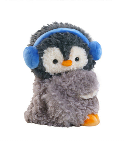 Fluffy grey penguin mini backpack with blue earmuffs worn over the shoulder with white straps.
