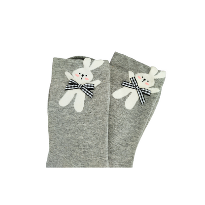 Grey knit crew socks with a plush white bunny near the cuff, featuring pink cheeks, embroidered eyes, and a black‑and‑white checkered bow.