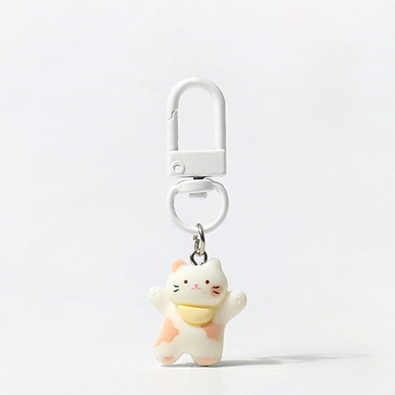 Set of three handmade kitty keychains with raised‑paw designs and matching carabiner clips in brown, white, and tri‑colour styles